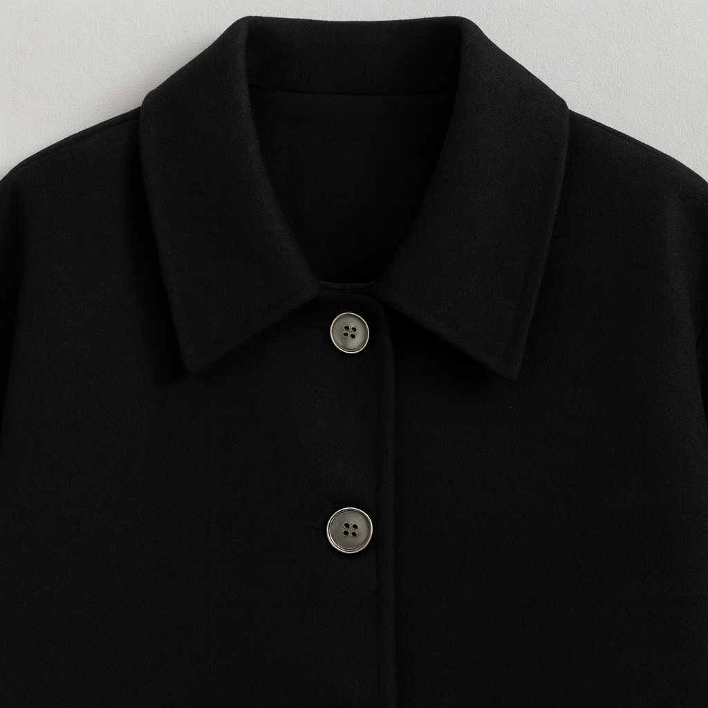 A loose-fit wool-blend coat with a turndown collar, button-up front, long sleeves, and side pockets.